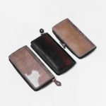 Genuine hair-on cowhide leather wallet with a natural black and white pattern and zipper closure.